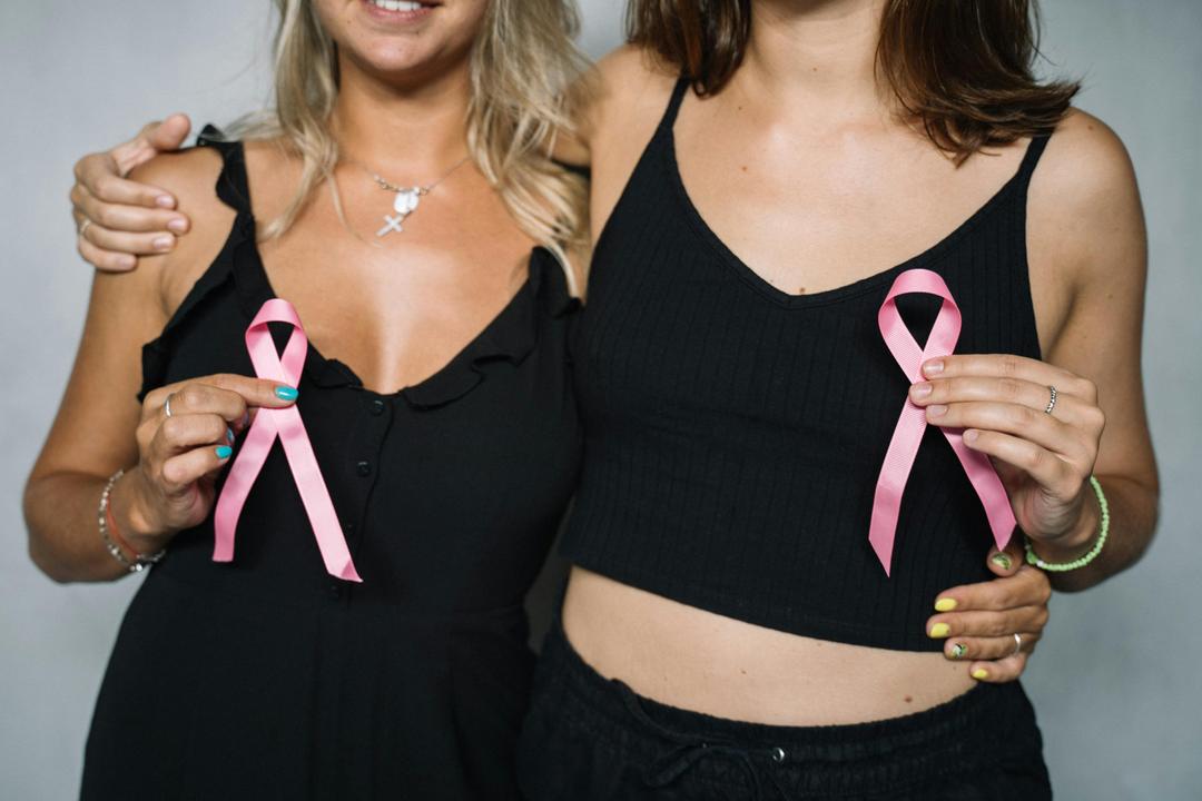 two girls with pink ribbons for breast cancer awareness