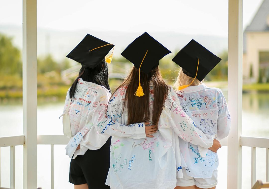 graduates in caps hugging