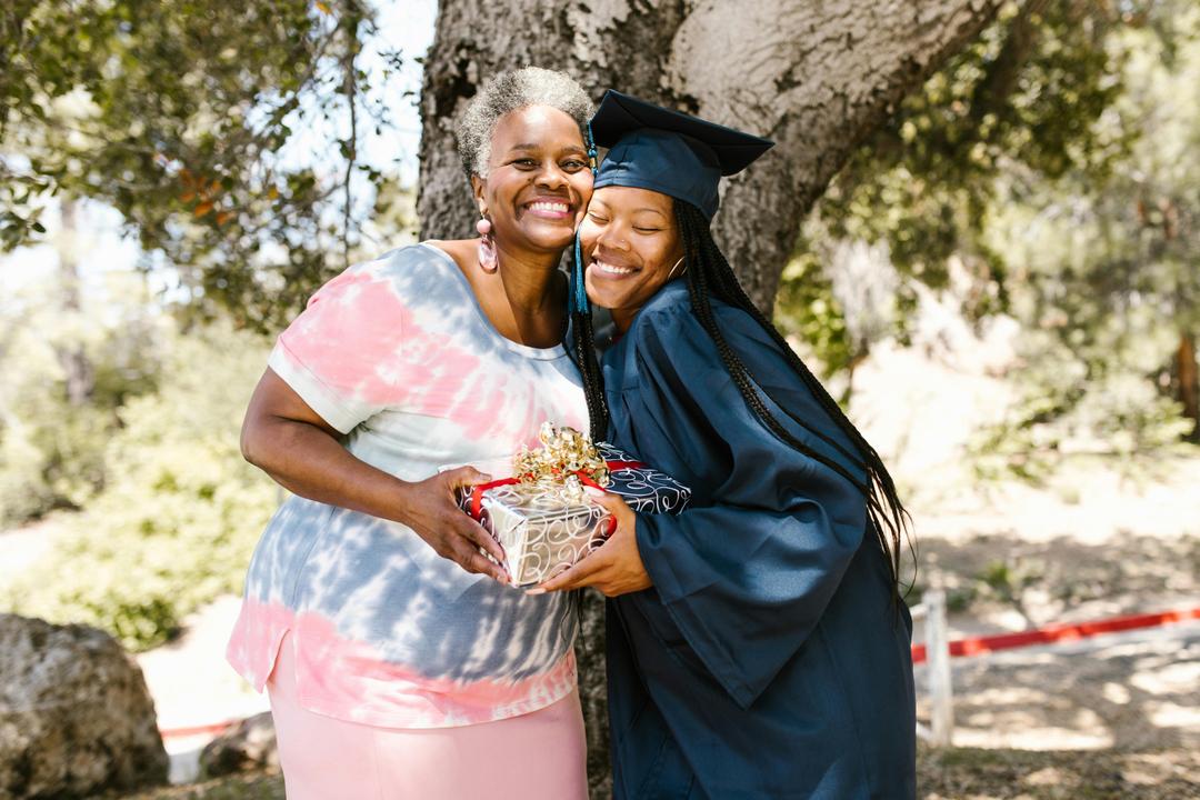 smiling graduate with her grandma giving her a gift